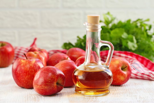 Apple vinegar. Bottle of apple vinegar on wooden background.