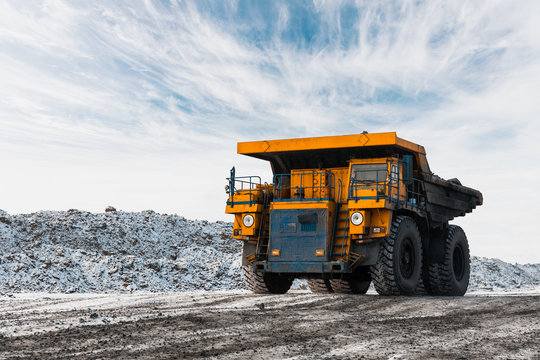 Large quarry dump truck. Loading the rock in dumper. Loading coal into body truck. Production useful minerals. Mining truck mining machinery, to transport coal from open-pit as the Coal Production.
