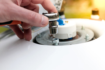 repair of boilers, the hand of the master throws and twists the nuts, close-up