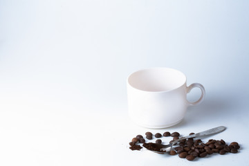 Coffee cup and beans on old kitchen table.