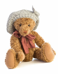 Teddy bear sitting with a gray wool hat