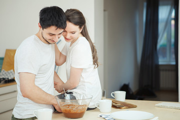 Obraz na płótnie Canvas Woman sitting on table, hugging her husband
