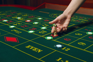 Roulette table with chips. Winning combination. Hand of Croupier with dolly.