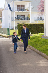 Happy mother and son going to school.