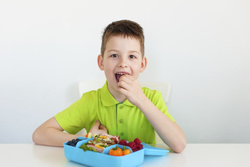 One young boy eating a healthy school lunch