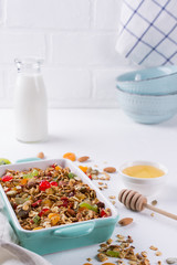 Baked granola in the baking tray and various delicious ingredients for healthy breakfast