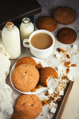 Oatmeal cookies, Books, Oatmeal Flakes, Cup of Coffee with Milk, Raisins on a light background. The concept of Good Morning and Breakfast. Top view