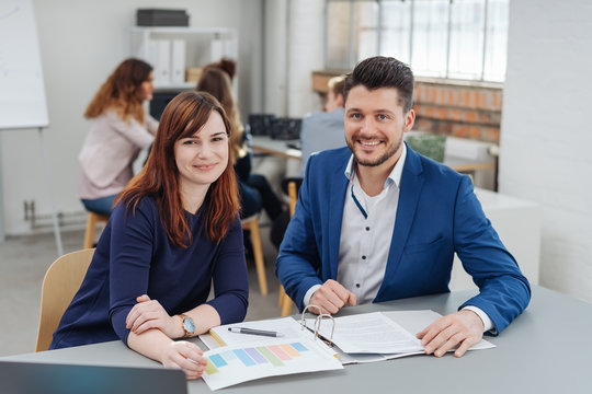 Young woman working with co-working man in office