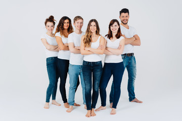 Group of friendly barefoot young friends in jeans