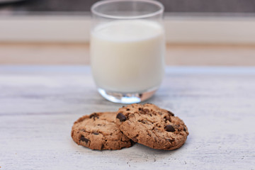 Chocolate chips cookies/ American cookies/ and healthy glass of milk at light wooden background/ Healthy morning