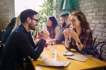 Handsome man flirting with cute woman in restaurant