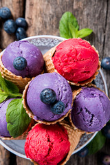 Ice cream, Strawberry and blueberry ice cream scoop in cone on wooden table. 