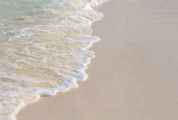 Sea wave and sand beach photo for background. Sunny beach sand with sea wave.