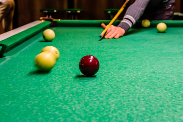 Player arm with the cue and balls on the green cloth. Russian billiard