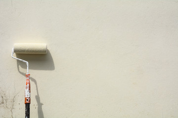paint roller at the white cement wall