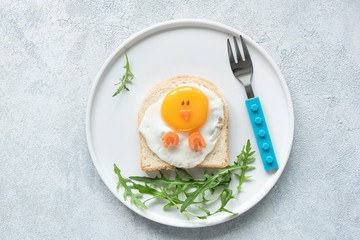 Food art chicken sandwich for kids. Cute egg sandwich shaped as chicken on white plate. Top view