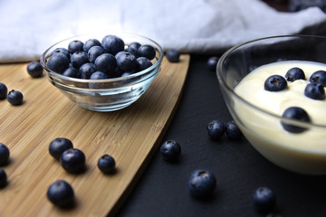Blueberry yogurt in glass bowl on wooden table