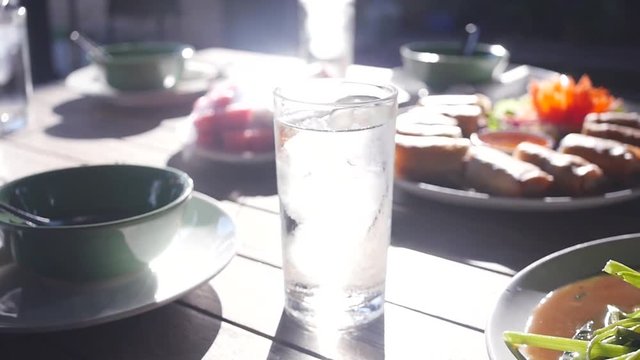 An invigorating glass of cold water at dinner with beautiful glare from the sun. slow motion. 1920x1080. full hd