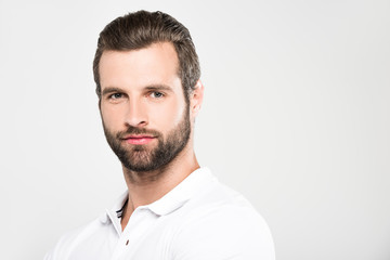 Fototapeta premium portrait of handsome bearded man looking at camera, isolated on grey