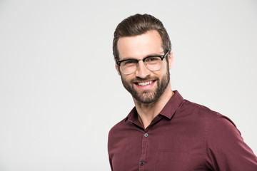 portrait of handsome cheerful man in eyeglasses, isolated on grey