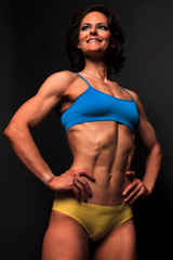 Fototapeta na wymiar Fitness woman posing against a black background