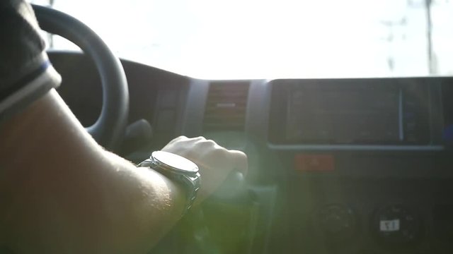 The man cuts out a box of fart in the car, lit by the rays of the sun with glare on the hand watches. slow motion. 1920x1080. full hd