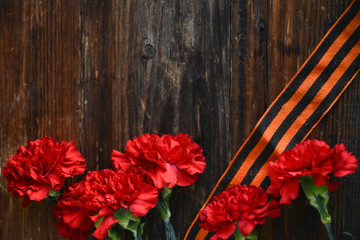 background for postcards by may 9, victory day: cap, letters, red carnations and St. George ribbon Soviet icons and old photos