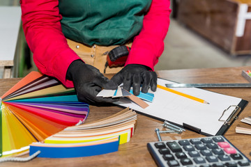 Beautiful smiling carpenter with colour samples close up