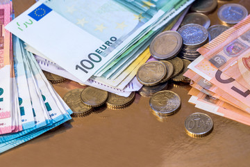 euro coin and banknotes isolated on gold