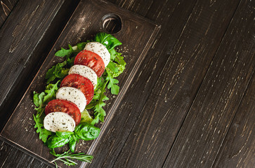 Fresh salad with tomatoes, mixed greens ,nuts, eggs, on wooden background . Healthy food.