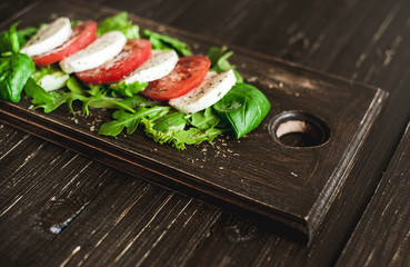 Fresh salad with tomatoes, mixed greens ,nuts, eggs, on wooden background . Healthy food.