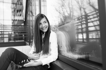 A teenage girl with a smartphone in her hands spends time outdoors