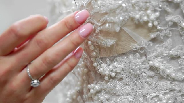 Close-up fashion designer for brides in his Studio pins needles lace wedding dress. Seamstress creates an exclusive wedding dress. Secure with pins and needles outline. Small private business