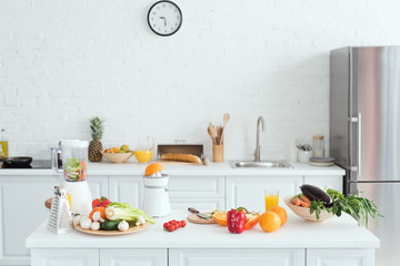 interior of white light kitchen with delicious fruits and vegetables on kitchen counter