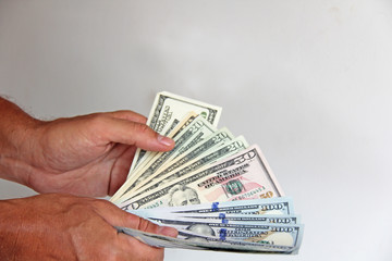 The man's hand holds US dollars, counts them and pays. Paper money dollars in hand