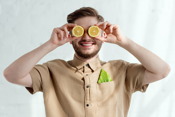 obscured view of smiling man with lemon pieces and savoy cabbage leaf in pocket, vegan lifestyle concept