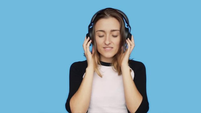 Slow motion of beautiful young female, woman, teenager or millennial hipster listen and enjoy favorite playlist song or music track, move with rhythm to beat, smile and chuckle in satisfaction