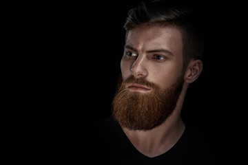 Studio shot of confidence attractive hipster Dramatic light concept Black background Copy space Bearded man