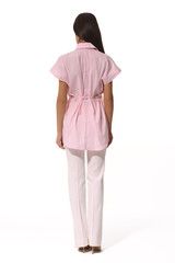 young caucasian business woman executive posing in summer pink powder short sleeve blouse white trousers high heels stiletto shoes full body length isolated on white back view