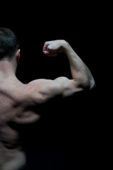 Man athlete with half torso, back view. Sportsman flex arm muscles. Bodybuilder show biceps and triceps. Workout and training activity in gym. Sport power and bodycare concept