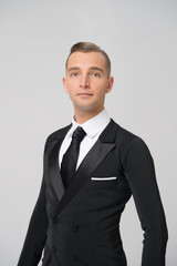 Ballroom dancer in stylish tuxedo. Man in elegant suit with tie. Groom dressed for wedding or holiday celebration. Dress code for businessman. Fashion style and trend concept