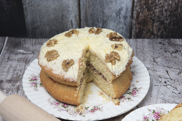 Large coffee and walnut cake on a wooden background