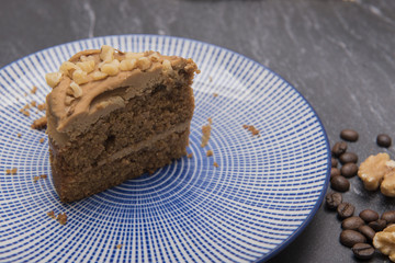 Slice of coffee and walnut cake on a blue plate