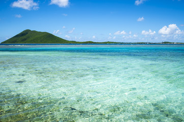 Fototapeta na wymiar Bright, clear and calm turquoise waters over a Caribbean reef surrounding a paradise island