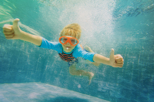 happy boy swim underwater with thumbs up