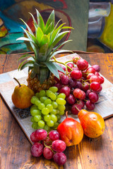 Grapes, pineapple and pear on wooden table