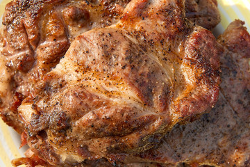 Obraz na płótnie Canvas Close up view of juicy pork steak cooked on an open flame grill on big white plate..