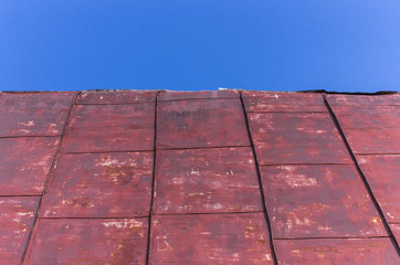 Old tin roof of a house under a blue sky