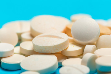 Pills are scattered over a blue background