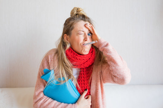 Funny picture of sick woman measuring temperature with thermometer in her mouth
